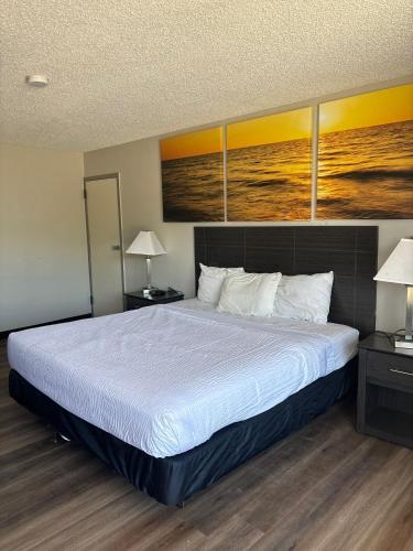 a large bed in a room with two lamps at Days Inn by Wyndham Caddo Valley Arkadelphia in Caddo Valley