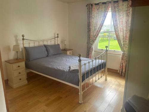 a bedroom with a bed and a window at Katy Kellys Countryside Self Catering Cottage in Roscommon