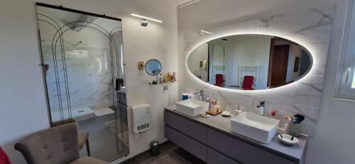 une salle de bain avec deux lavabos et un grand miroir dans l'établissement Beautiful air-conditioned villa 10 m Aix, à Éguilles