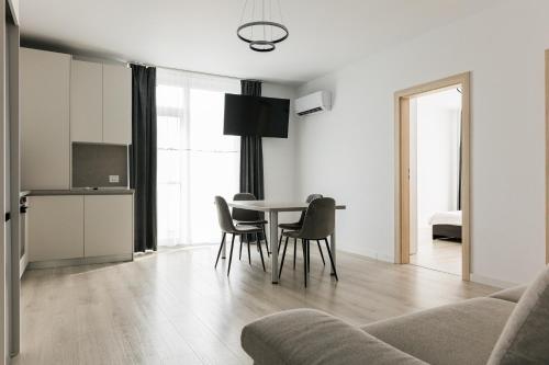 a kitchen and dining room with a table and chairs at Corner Apartment in Bistriţa