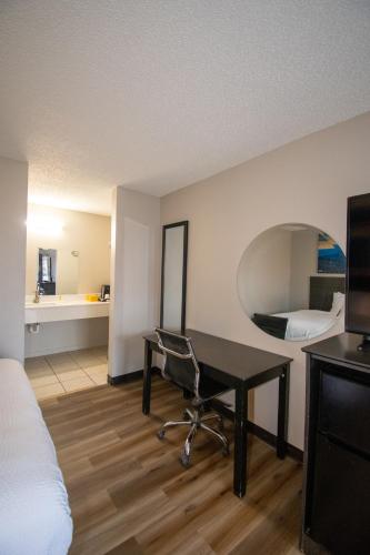 a hotel room with a desk and a bed at Days Inn by Wyndham Caddo Valley Arkadelphia in Caddo Valley