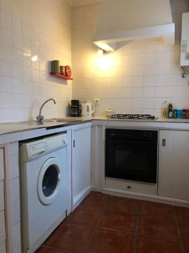 a kitchen with a washing machine and a sink at GuestReady - Ponta Delgada city house in Ponta Delgada