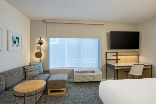 a hotel room with a couch and a tv at TownePlace Suites by Marriott Mankato in Mankato