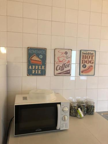 a microwave on a counter with signs on the wall at GuestReady - Ponta Delgada city house in Ponta Delgada