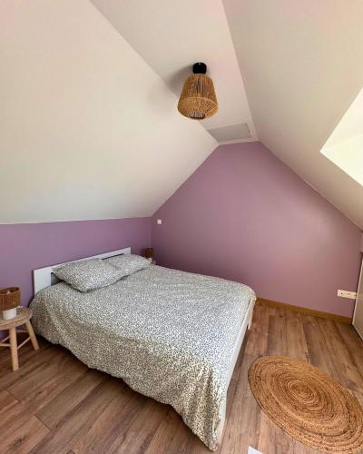 - une chambre avec un lit et un mur violet dans l'établissement Le Bleu d'Opale, à Sangatte