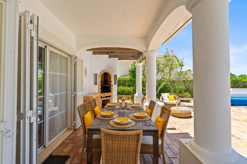 a dining room with a table and chairs on a patio at Peaceful 4BR villa on Gramacho golf resort w/ private pool in Lagoa