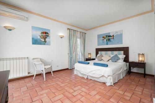 a bedroom with a bed and a table and a chair at Peaceful 4BR villa on Gramacho golf resort w/ private pool in Lagoa