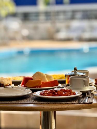 een tafel met borden eten en fruit erop bij Las Brisas Beach Hotel in Natal