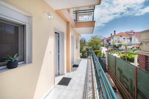 a balcony with white walls and a green fence at My Sunflower in Nea Fokea