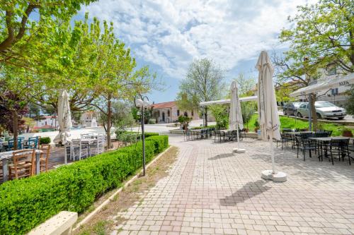 a patio with umbrellas and tables and chairs at My Sunflower in Nea Fokea