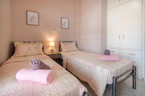 two beds in a room with pink towels on them at My Sunflower in Nea Fokea