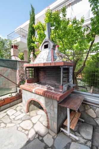 a stone oven with two birds sitting on top of it at My Sunflower in Nea Fokea