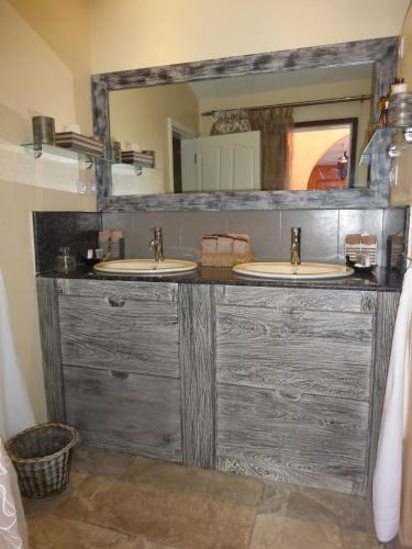 a bathroom with two sinks and a large mirror at RIAD SAINT FRANCOIS & SPA in Rodrigues Island