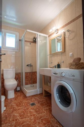a bathroom with a washing machine and a toilet at Casa Freya in Alexandroupoli