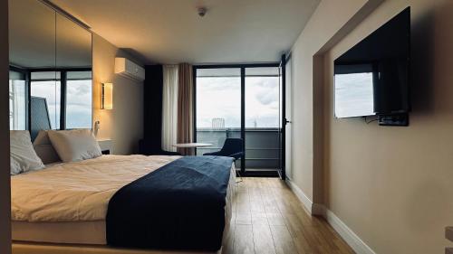 una habitación de hotel con una cama y una ventana en BEST VIEW APARTMENTS ORBI CITY D1 BLOCk, en Batumi