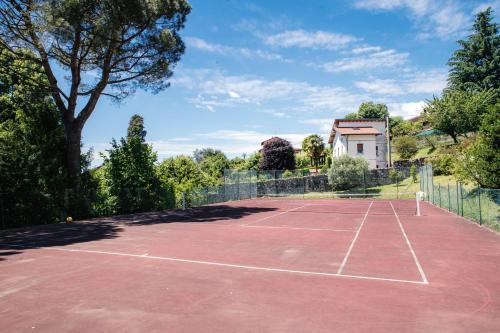 a tennis court in front of a house at Villa Solzago - by MyHomeInComo in Tavernerio