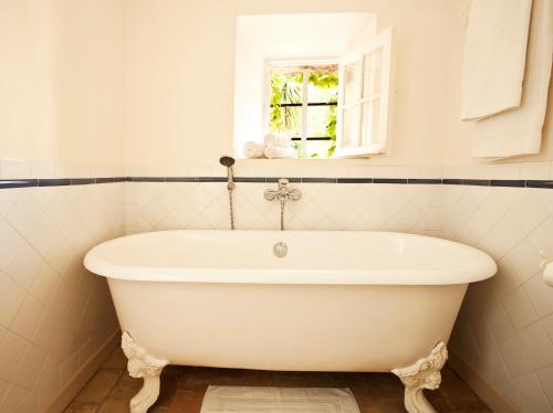 a white bath tub in a bathroom with a window at Maison Jolie in Saint-Tropez