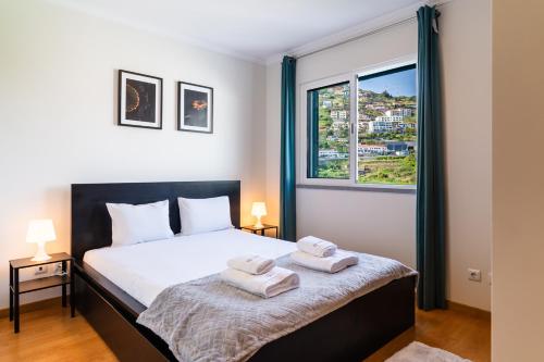 a bedroom with a bed with two towels on it at GuestReady - Calm Haven in Madeira in Caniço