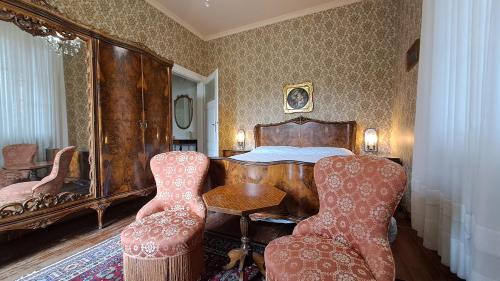 una habitación con una mesa y sillas y una cama en B&B Villa Margherita, en Lesa