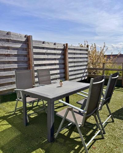 une table de pique-nique et des chaises sur l'herbe dans l'établissement Le Sunset, à Sangatte