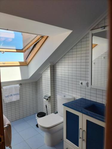 a bathroom with a toilet and a skylight at Capricho de Bascuas in Bascuas