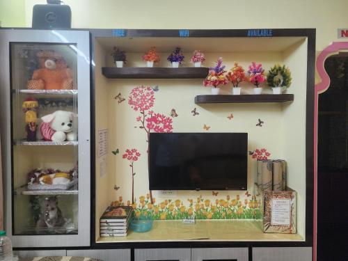 a tv on a wall with flowers on it at Sri Sakthi Home Stay - Beyond the Expectations - We maintain standards in Tirupati
