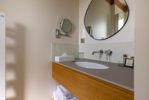 a bathroom with a sink and a mirror at Family Golf Hotel in Royan