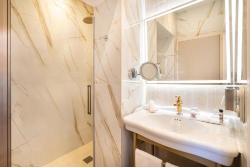 a bathroom with a sink and a shower at Grand Hotel Des Lecques; BW Signature Collection in Saint-Cyr-sur-Mer
