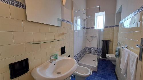 Un baño con lavabo, inodoro y ducha. en B&B Villa Margherita, en Lesa