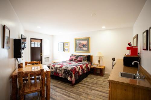 a bedroom with a bed and a sink in a room at Riverwood Resort on the Gunnison in Delta