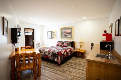 a bedroom with a bed and a sink in it at Riverwood Resort on the Gunnison in Delta