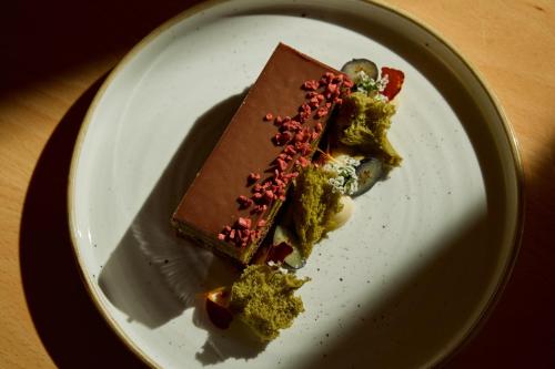 a white plate with a piece of cake and broccoli at Crowne Plaza Adelaide by IHG in Adelaide