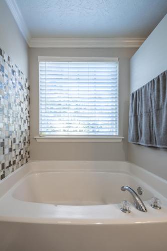 a white bath tub in a bathroom with a window at ThrillStay Braves & Six Flags Family House in Lithia Springs