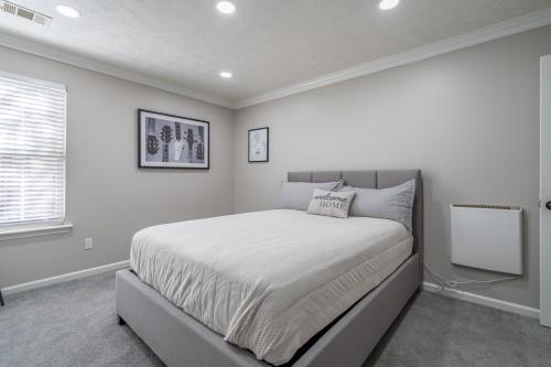 a bedroom with a large bed with white walls at ThrillStay Braves & Six Flags Family House in Lithia Springs