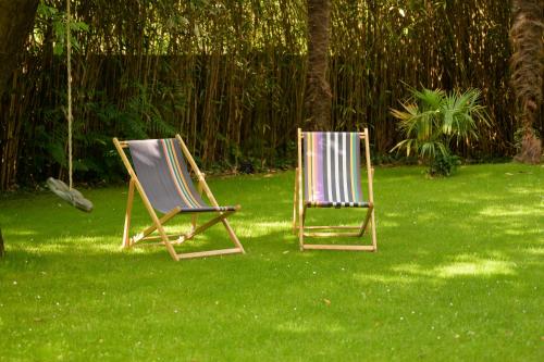 deux chaises assises sur l'herbe dans une cour dans l'établissement Villa Sofi vacances près du Golf d'Hossegor Hâvre de paix 8 Pers, à Soorts-Hossegor