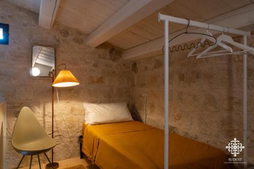 a bedroom with a bed and a lamp and a chair at Casa Aia - Rifugio Naturalistico in Frigintini