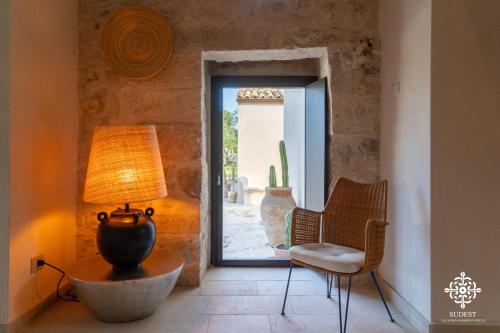 a room with a lamp and a chair and a door at Casa Aia - Rifugio Naturalistico in Frigintini