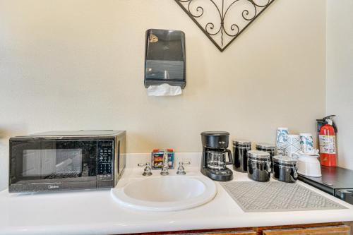 a kitchen counter with a microwave and a sink at Golf, Fish and More Cozy Safari Unit in Atwater! in Atwater