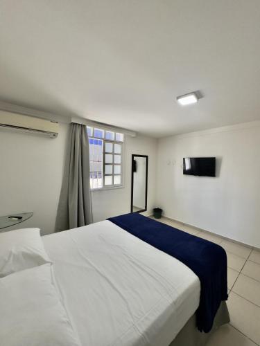 a bedroom with a large white bed and a window at Las Brisas Beach Hotel in Natal