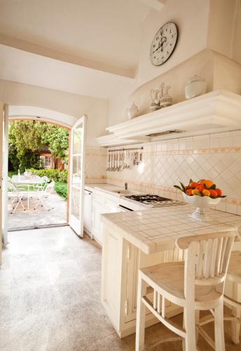 a kitchen with a table and a clock on the wall at Maison Jolie in Saint-Tropez