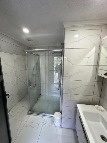 a bathroom with a shower and a sink at Azhara Bungalow in Soğuksu