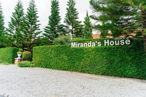 a hedge with a sign for a mirandaannis house at Miranda's House Khaokho มิรันดาเฮ้าส์ เขาค้อ in Ban Lao Kok Kho