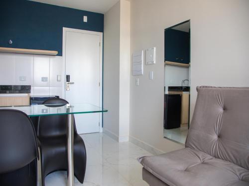 a kitchen with a glass table and a chair at Slim Curitiba João Bettega in Curitiba
