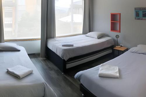 a room with two beds and a window at Casa central el mejor distrito in Bogotá