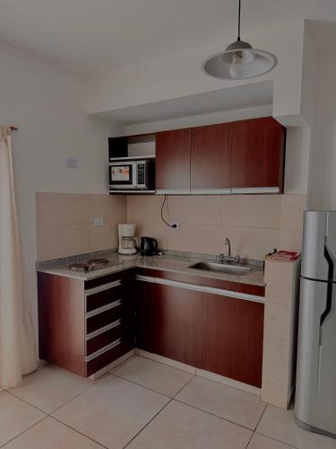 a kitchen with a sink and a microwave at Loano II - Confort Moderno en Primer Piso con acceso por escalera! in Belén de Escobar