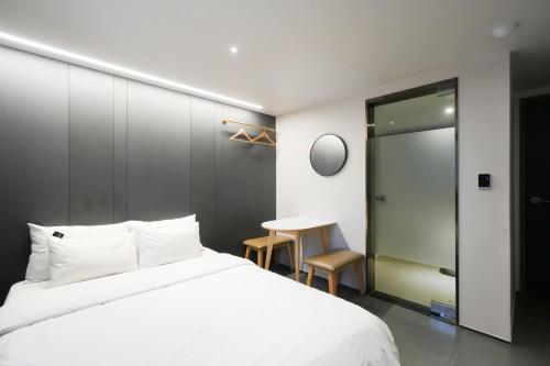 a bedroom with a white bed and a table at Hotel Home in Seoul