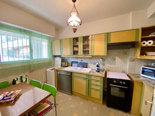 une cuisine avec des armoires jaunes et vertes et une table dans l'établissement Nice West Pretty one bedroom, à Nice