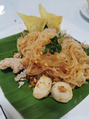 een bord met noedels op een bananenblad bij Amphawa Horse Farm Resort in Ban Bang Khan Taek (1)