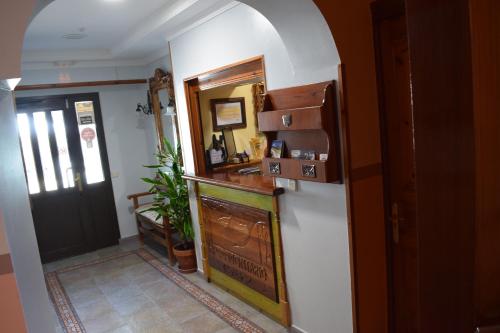 a hallway with a counter and a door with a mirror at Pensión Montarto in Arties