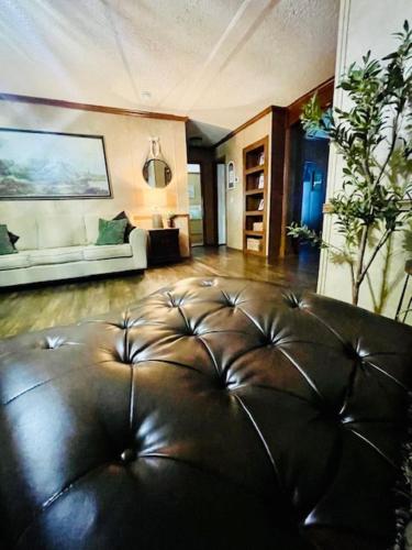 a living room with a couch and a leather ottoman at Mark House in Hammond